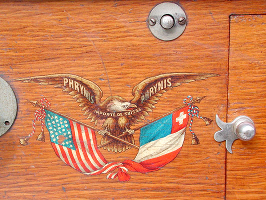 Das Phrynis Markenzeichen mit Adler und den Fahnen /  Eagle and banners forms the trade mark by Phrynis